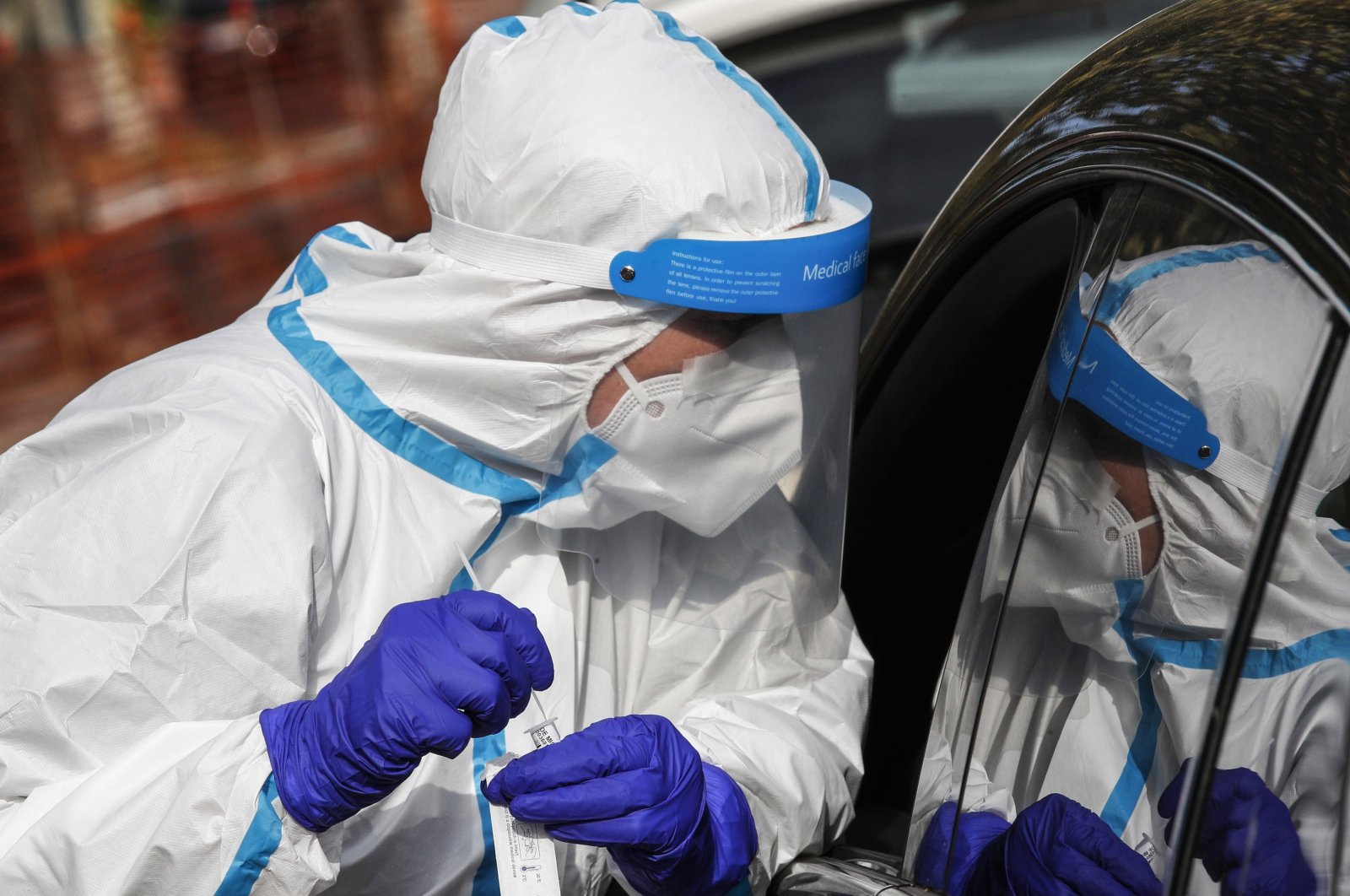 Health workers, wearing overalls and protective masks, perform swab tests in a parking lot, in Tor di Quinto avenue, Rome, Italy, Oct. 22, 2020. (EPA Photo)