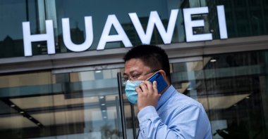 A man walks past a shop for Chinese telecommunications giant Huawei in Beijing, May 25, 2020. ( AFP Photo)