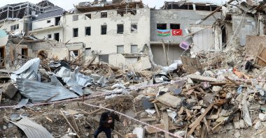 A man walks among the debris of destroyed buildings hit by Armenian shelling, in a residential area of the city of Ganja, Azerbaijan, on Oct. 22, 2020. (AFP Photo)