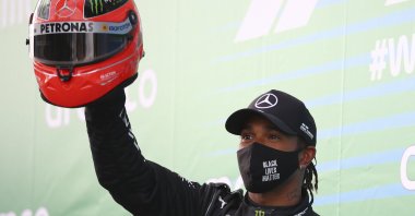 Lewis Hamilton shows a helmet of legendary driver Michael Schumacher, which was gifted to him, after he wins the Eifel Grand Prix in Nuerburg, Germany, Oct. 11, 2020. (AP Photo)