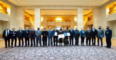 Representatives of Libya's two rival factions pose with the head deputy special representative of the U.N. Secretary-General for Political Affairs in Libya Stephanie Williams (9R) after a signing ceremony in Geneva, on Oct. 23, 2020. (AFP Photo)