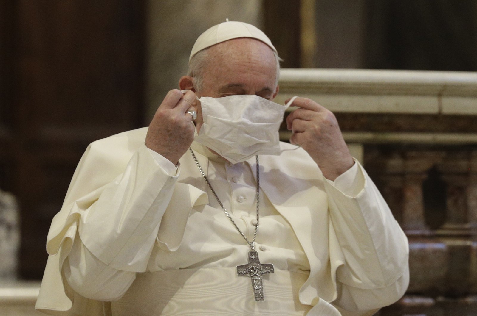 Pope Francis puts on his face mask as he attends an inter-religious ceremony for peace in the Basilica of Santa Maria, Aracoeli, Rome, Oct. 20, 2020. (AP Photo)