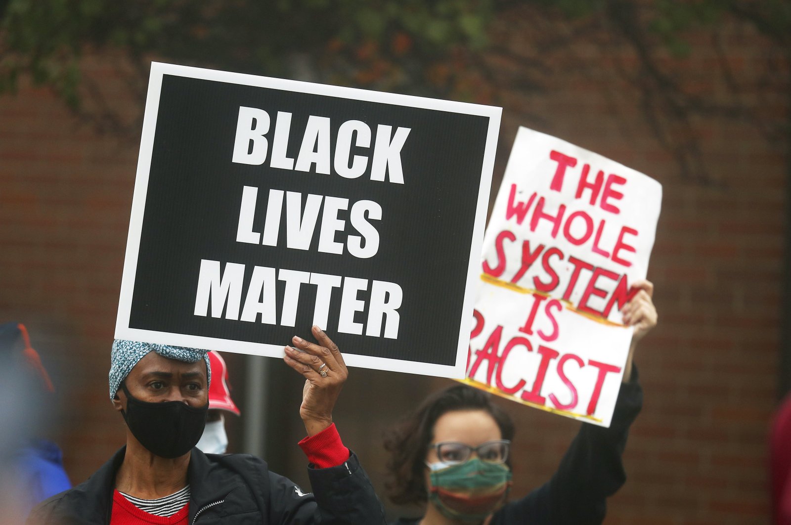 People hold signs during a protest rally for Marcellis Stinnette who was killed by Waukegan Police last Tuesday in Waukegan, Illinois, Oct. 22, 2020. (AP Photo)