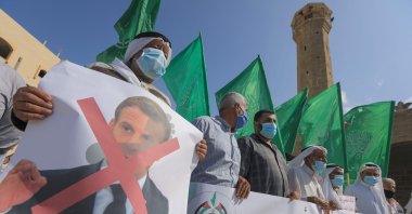 Palestinian demonstrators lift flags and placards during a rally to protest comments of French President Emmanuel Macron over Prophet Muhammed cartoons, in Deir al-Balah in the central Gaza Strip, Oct. 25, 2020. (AFP)