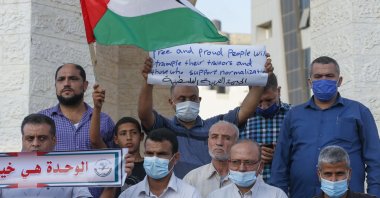 Palestinian demonstrators lift placards protesting the Sudan normalization agreement with Israel, in Rafah town in the southern Gaza Strip on Oct. 24, 2020.  (AFP Photo)
