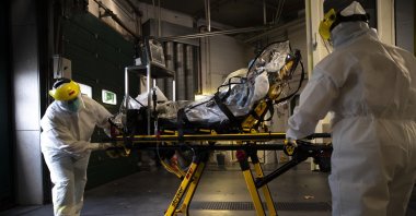 Medical staff transfer a COVID-19 patient from the CHR Citadelle hospital in Liege, Belgium, Oct. 21, 2020. (AP Photo)