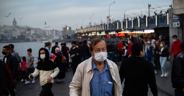 A man, wearing a face mask, walks near the Galata bridge, in Istanbul, Turkey, Oct. 25, 2020. (AFP Photo) 