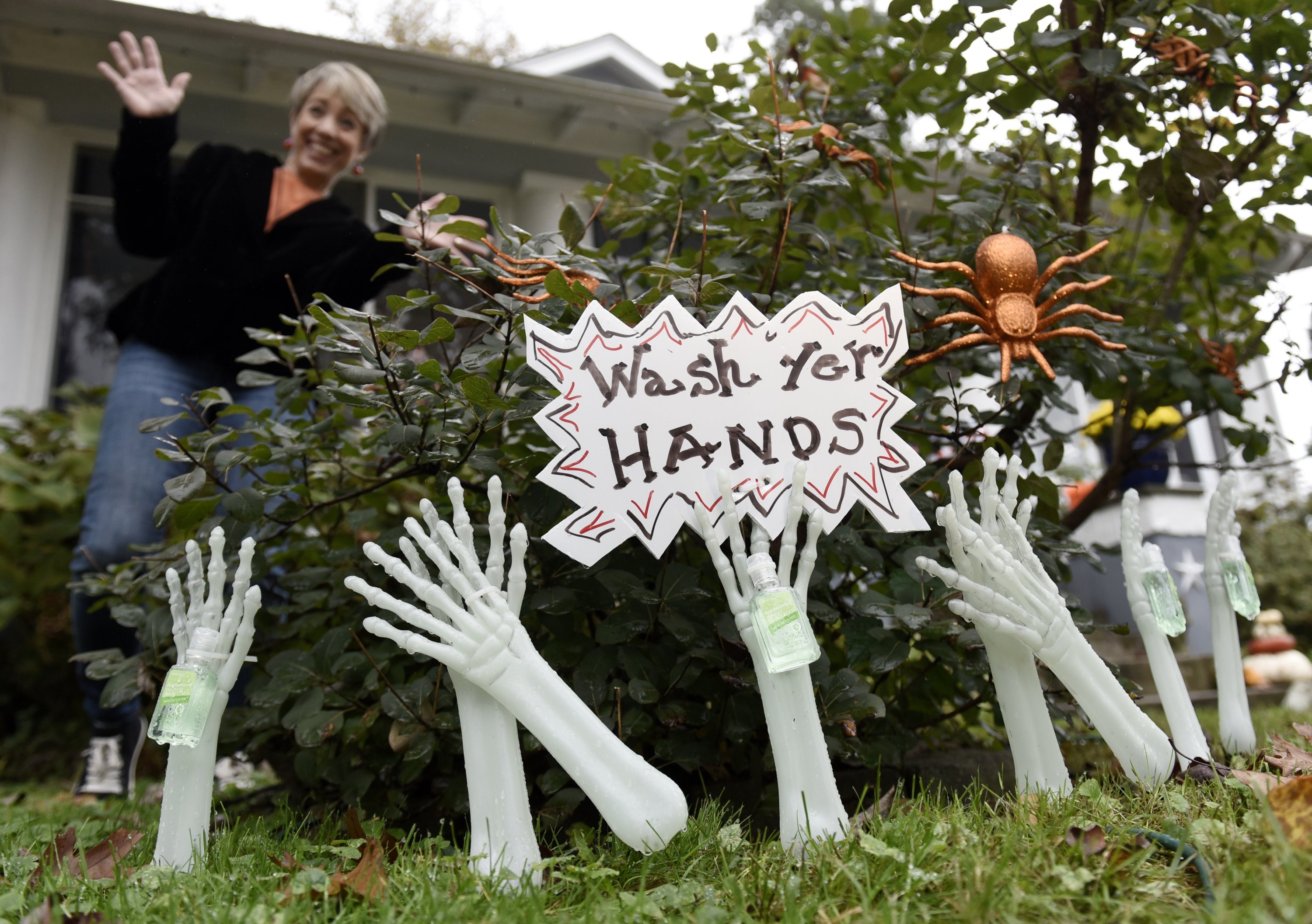 Carol McCarthy is seen behind Halloween decorations that are holding hand sanitizer at her home, Monday, Oct. 26, 2020, in Palmyra, N.J. (AP Photo)