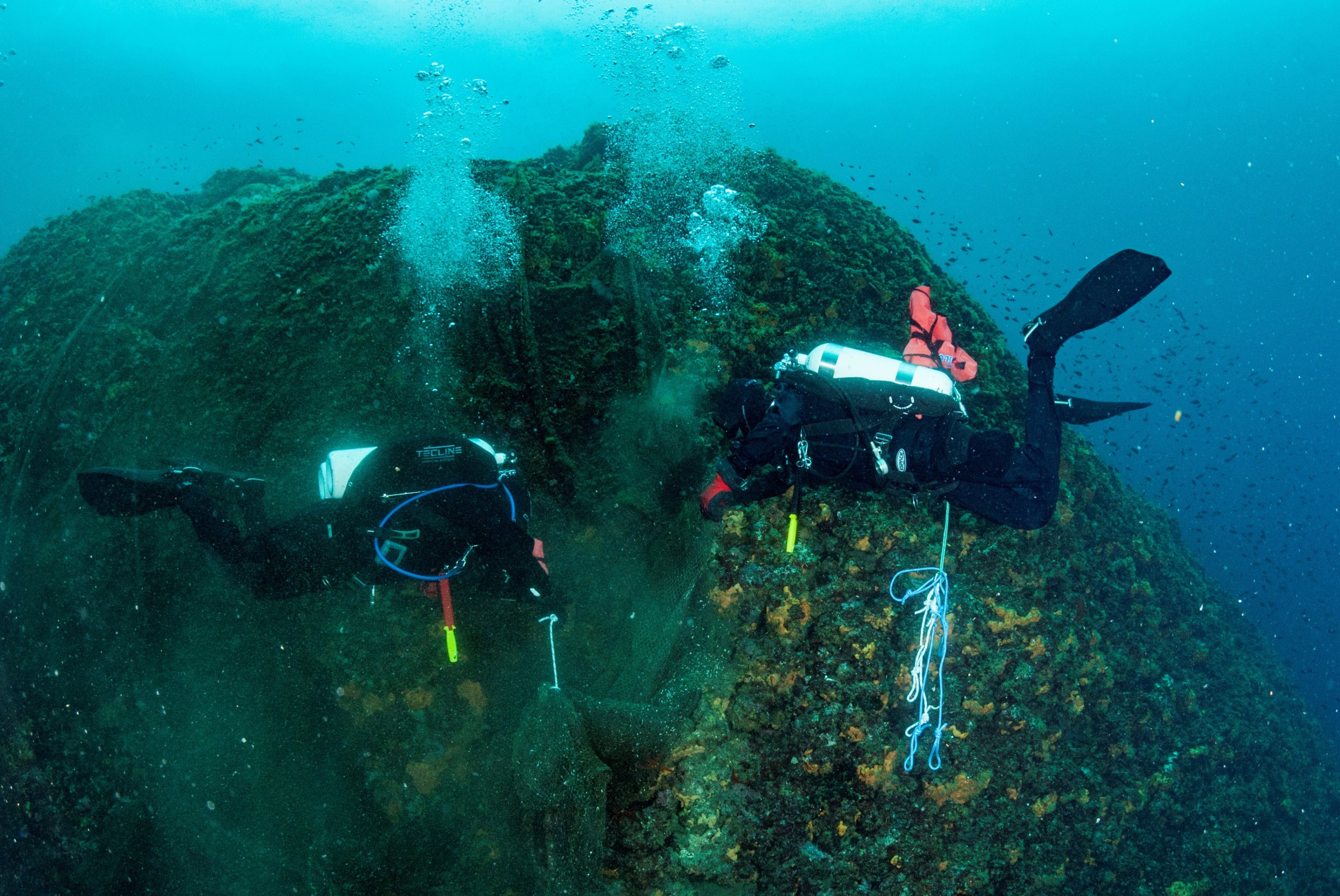 Divers attach a lifting bag to a ghost fishing net on the seabed in the village of Stratoni near Halkidiki, Greece, May 18, 2019. (Areti Kominou/Ghost Fishing Greece/Handout via REUTERS)