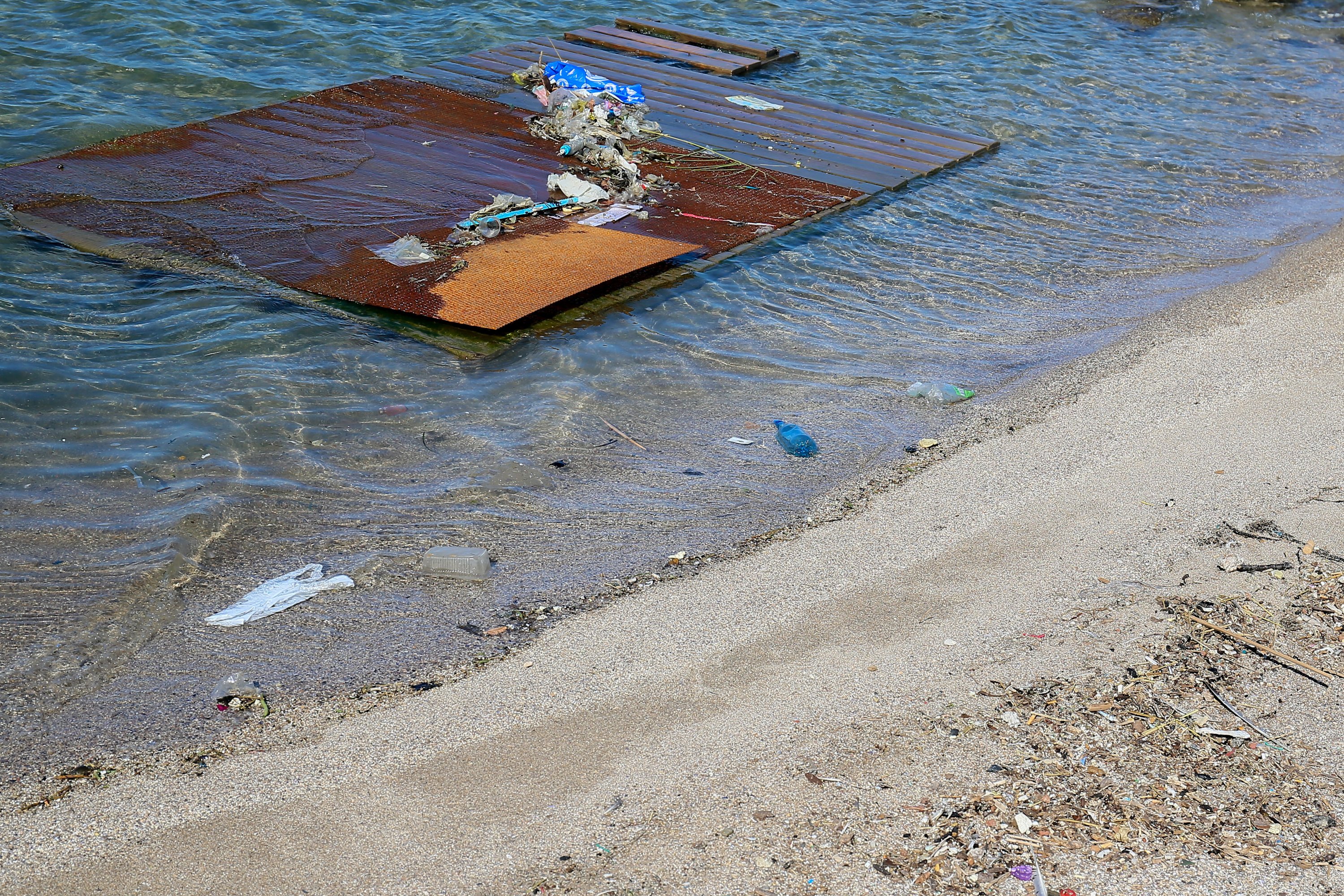 Plastic, wood and paper waste floating in the water along a beach, Sete, France, July 24, 2020. (via REUTERS)
