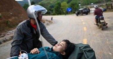 An injured woman is carried on a stretcher to an ambulance after being rescued from a landslide in Tra Leng commune in central Vietnam's Quang Nam province on October 29, 2020, in the aftermath of Typhoon Molave. (AFP Photo)