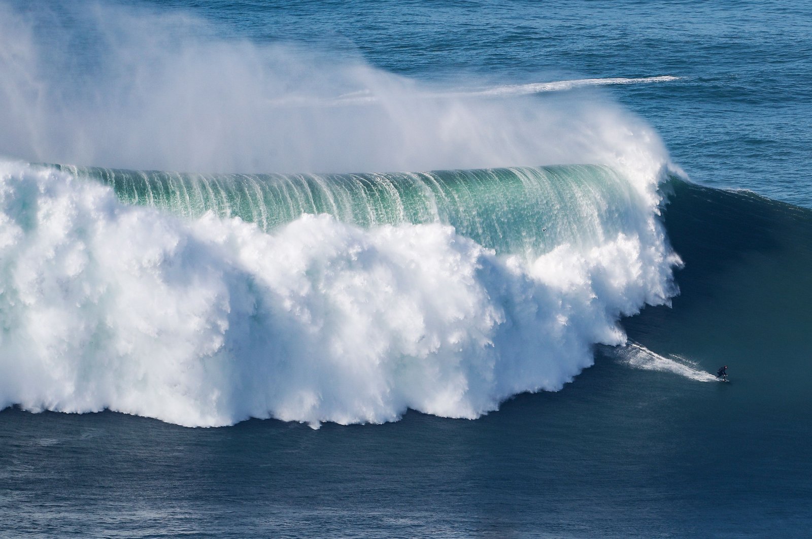 A surfer rides a wave amid a giant swell at Praia do Norte in Nazare, Portugal, Oct. 29, 2020. (AFP Photo)