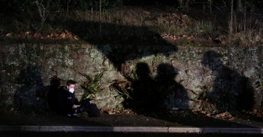 A journalist sits as demonstrators wave flags during a protest in Portland, Oregon, U.S., Oct. 29, 2020. (Reuters Photo)