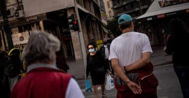 People, wearing protective face masks, walk in Athens' main commercial district on Oct. 30, 2020. (AFP Photo)