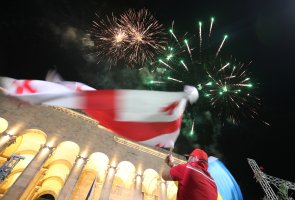 A man waves the Georgian national flag as supporters of the United National Movement party gather in front of the parliament building after exit polls were announced during the parliamentary election, in Tbilisi, Georgia Oct. 31, 2020. REUTERS/Irakli Gedenidze