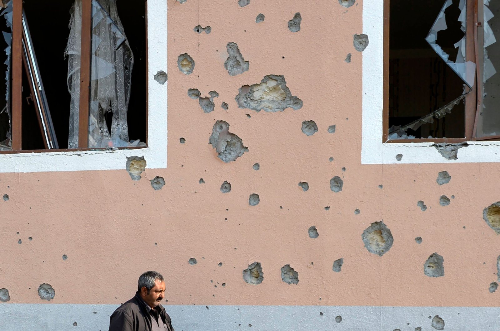 A man walks in front of a residential building damaged in Armenian shelling during the ongoing military conflict between Armenia and Azerbaijan over the Armenian-occupied region of Nagorno-Karabakh, in the town of Terter, Nov. 1, 2020. (AFP Photo)