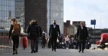 Commuters walk over London Bridge during the morning rush hour in central London, U.K., Nov. 2, 2020. (AFP Photo)