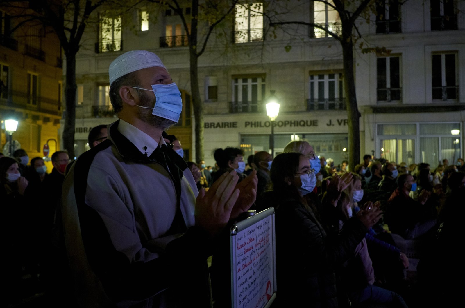 People gather on the Place de la Sorbonne to watch a live broadcast on a giant screen of the national tribute to the French history teacher Samuel Paty, who was killed in a terrorist attack, in the capital Paris, France, Oct. 21, 2020. (Photo by Getty Images)