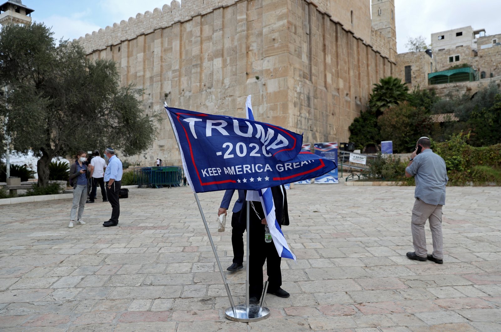 An Israeli settler adjusts a flag during a gathering to show support for U.S. President Donald Trump in the Israeli-occupied West Bank, Palestine, Nov. 2, 2020. (Reuters Photo)