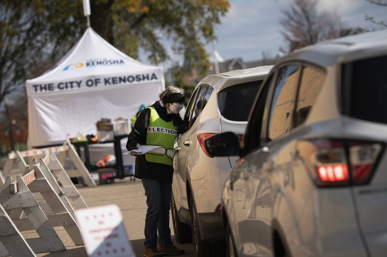 An elections staff member assists voters at Kenosha's municipal offices for drive-through early voting in Kenosha, Wisconsin, U.S., Oct. 30, 2020. (AP Photo)