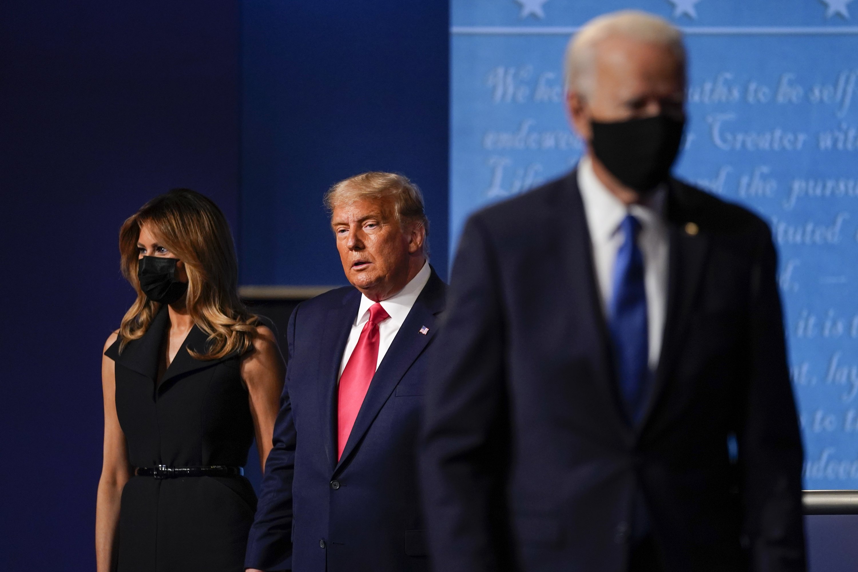 First lady Melania Trump, left, and President Donald Trump, center, remain on stage as Democratic presidential candidate former Vice President Joe Biden, right, walks away at the conclusion of the second and final presidential debate Thursday, Oct. 22, 2020, at Belmont University in Nashville, Tenn. (AP Photo/Julio Cortez)