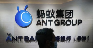 An employee walks past a logo of the Ant Group at their office in Hong Kong, China, Oct. 23, 2020. (AP Photo)