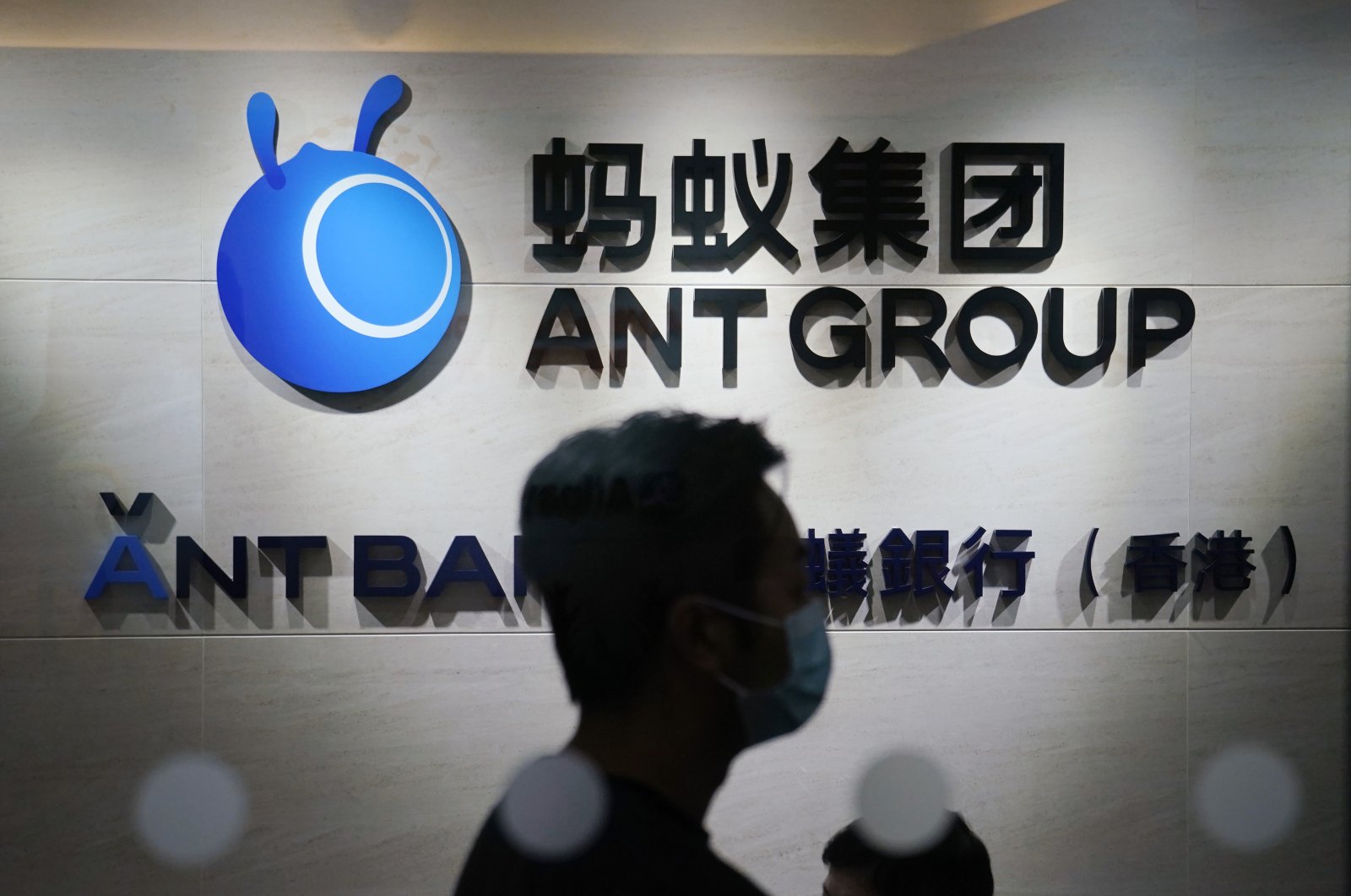 An employee walks past a logo of the Ant Group at their office in Hong Kong, China, Oct. 23, 2020. (AP Photo)