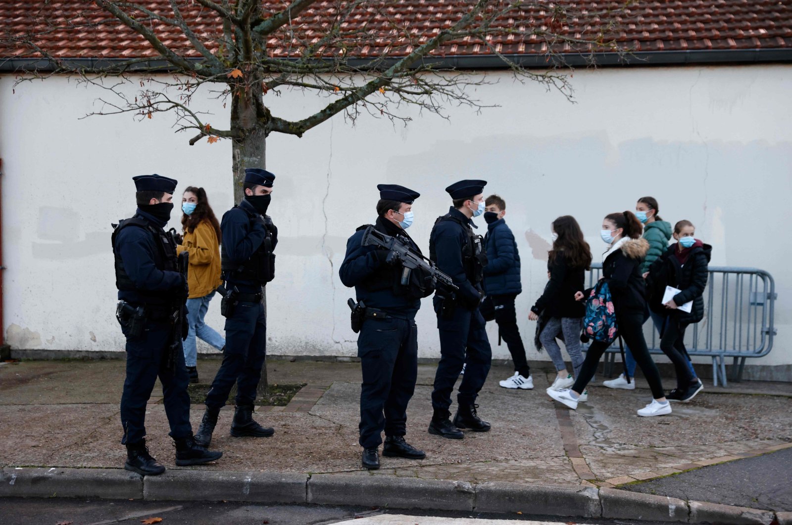A French CRS (Compagnies Republicaines de Securite) police officer stands near the entrance of Le Bois d'Aulne middle school in Conflans-Sainte-Honorine, Nov. 3, 2020. (AFP Photo)