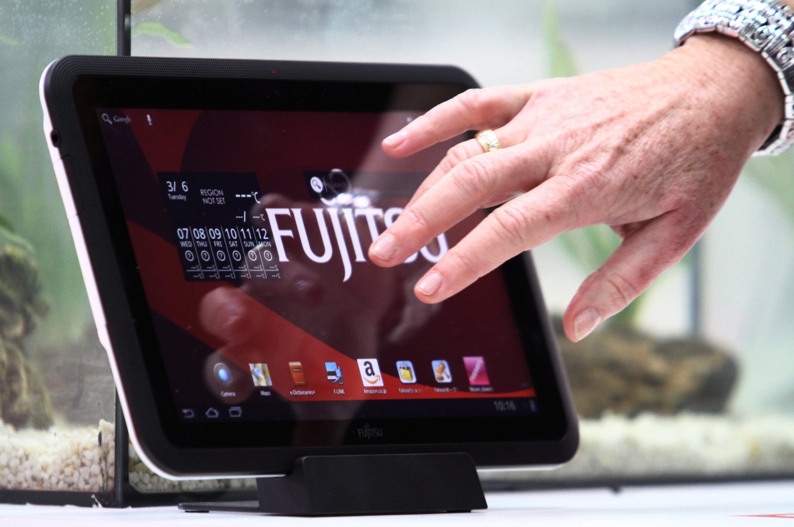 A woman touches a water resistant Fujitsu tablet PC at the information technology fair CEBIT in Hanover, Germany, March 6, 2012.  (EPA Photo)