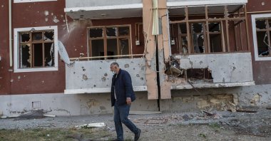 A man walks in front of a building damaged by Armenian shelling in the city of Tartar, Azerbaijan, Oct. 31, 2020. (AA Photo)