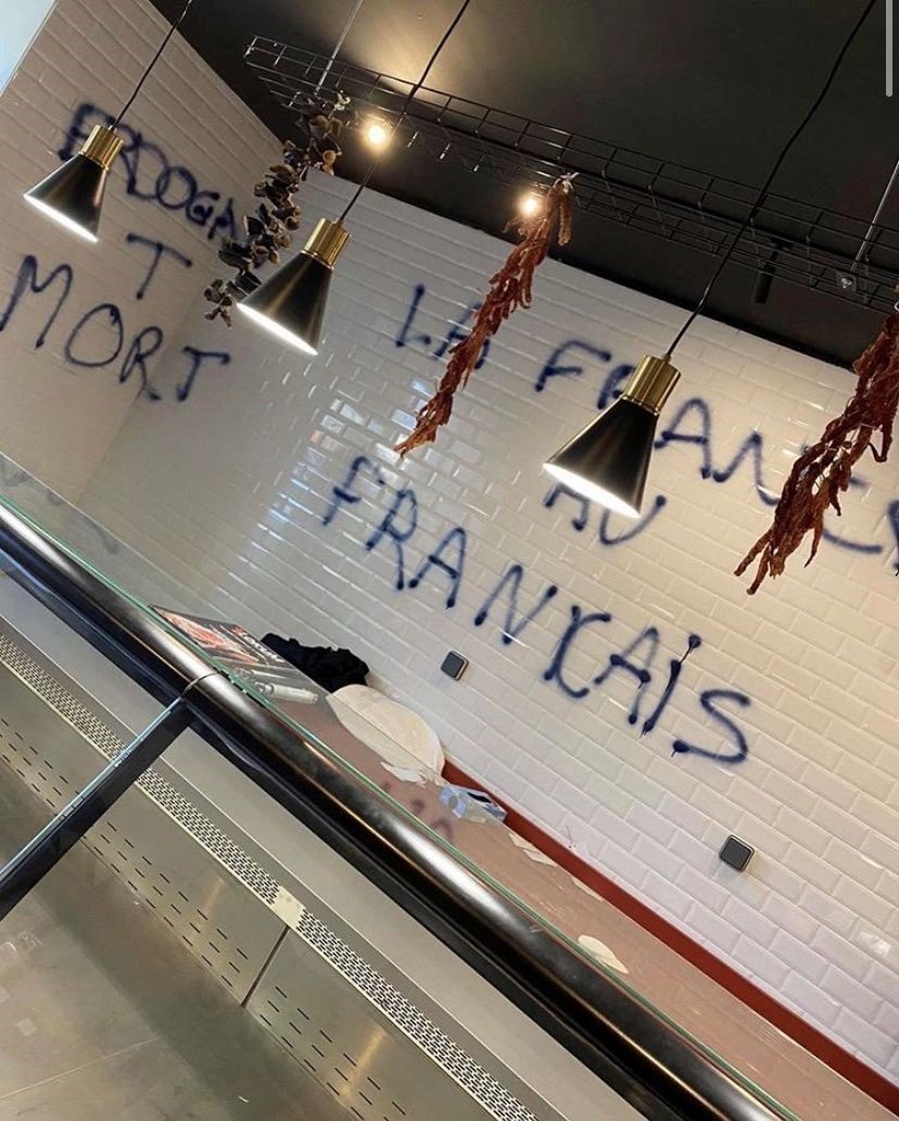 Racist slogans are seen spray-painted on the walls of the butcher shop in Nantes, France, Nov. 6, 2020. (IHA Photo)