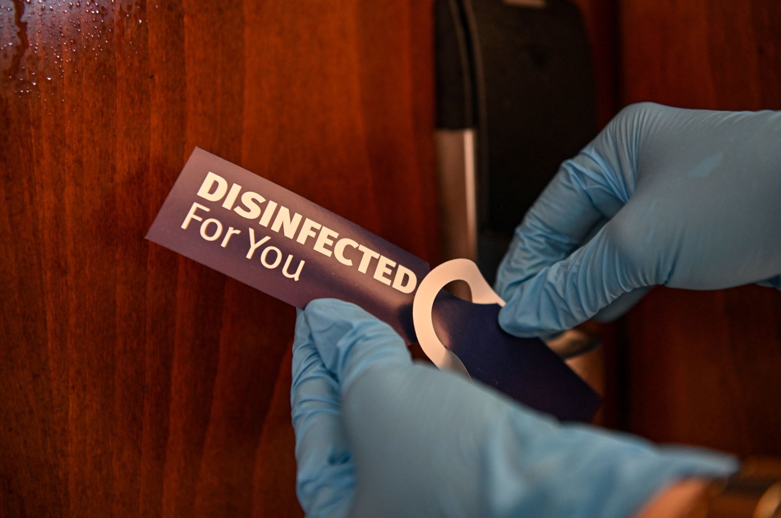 A room cleaner puts a sticker on a room's door after its disinfection at a luxury hotel in Lara district in Antalya, a popular holiday resort in southern Turkey, June 19, 2020. (AFP Photo)