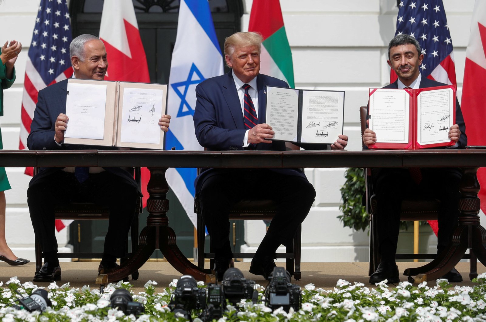 Israel's Prime Minister Benjamin Netanyahu, U.S. President Donald Trump and United Arab Emirates (UAE) Foreign Minister Abdullah bin Zayed display their copies of signed agreements as they participate in the signing ceremony of the Abraham Accords in Washington D.C., Sept. 15, 2020. (Reuters Photo)
