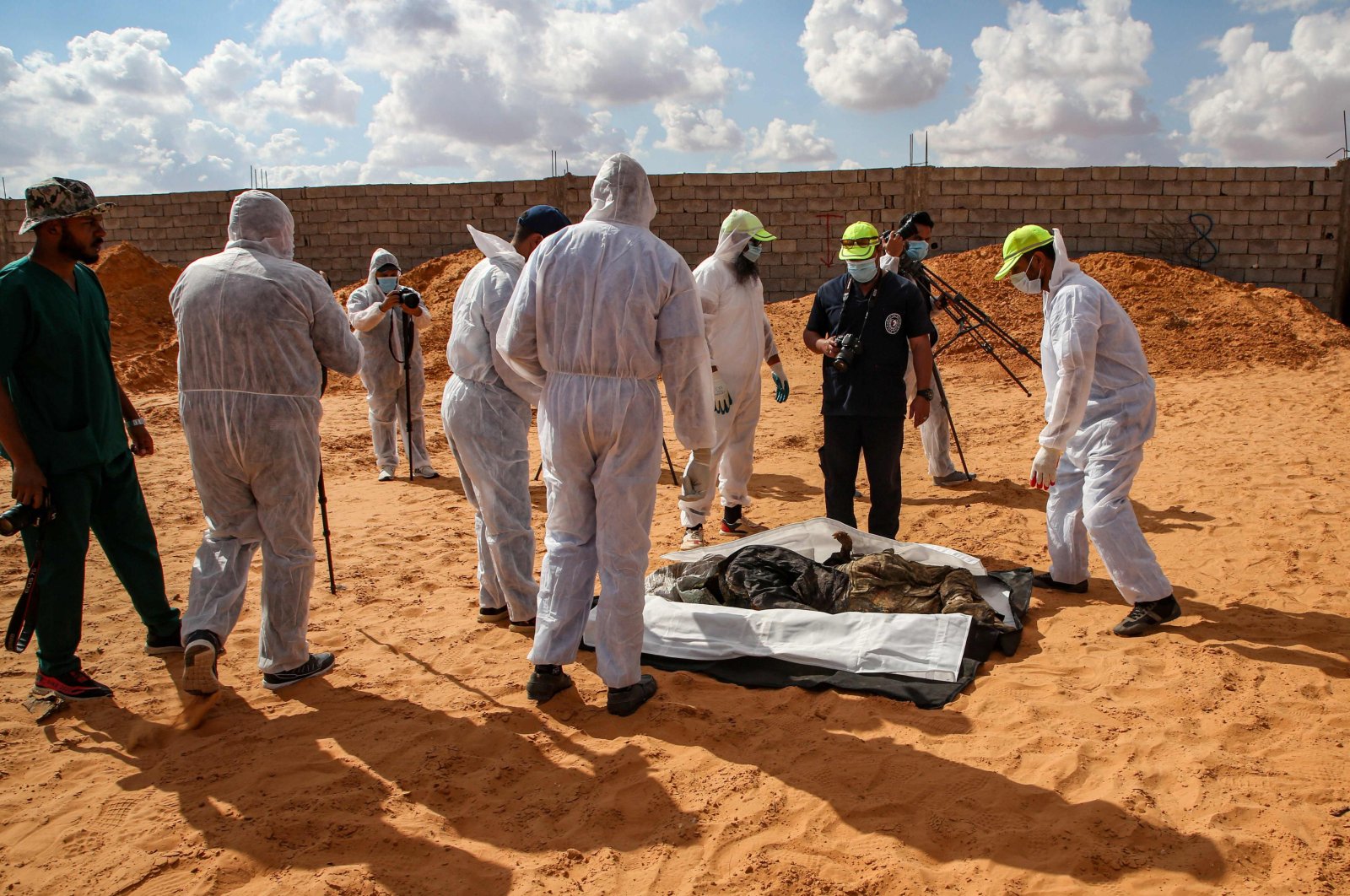 Members of the public body leading the "Search and Identification of the Missing," backed by the U.N.-recognised Government of National Accord (GNA), gather around an unearthed body at a mass grave site in western Libya's Tarhuna region on Nov. 7, 2020.