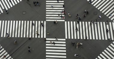 People walk across a pedestrian crossing along a shopping street, in Tokyo, Japan, Nov. 3, 2020. (AP Photo)