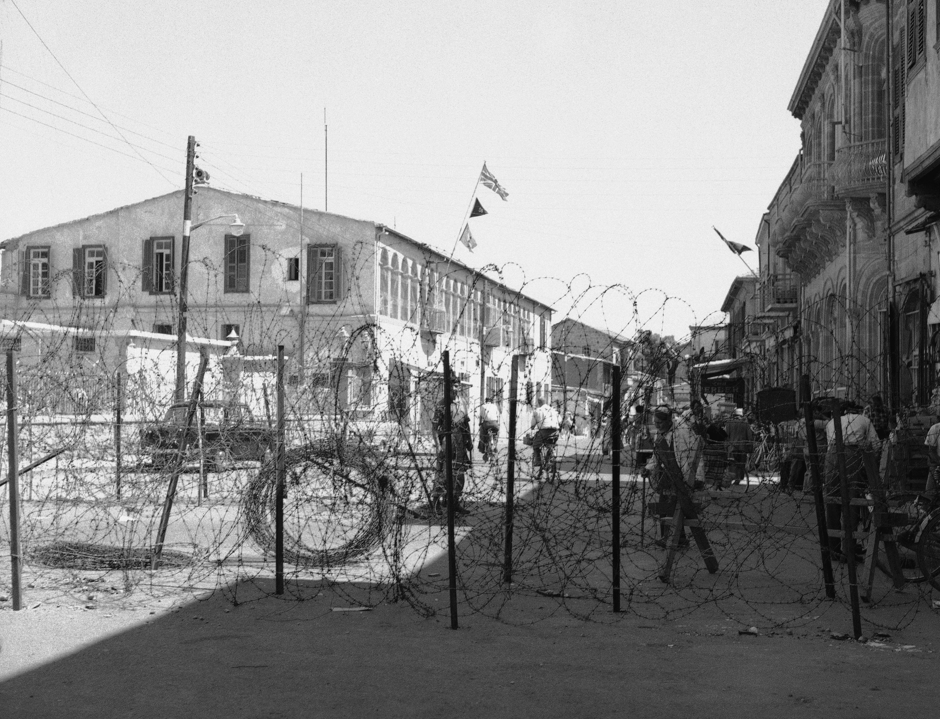 A barricade of barbed wire divides the Greek and Turkish quarters of Nicosia, Cyprus shown June 30, 1958. The Greek section is in the foreground. A British soldier (center) stands on guard behind the wire barrier. (AP Photo)