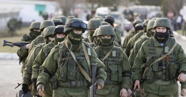 Russian servicemen walk outside the territory of a Ukrainian military unit in the village of Perevalnoye outside Simferopol in Russian-occupied Crimea, Ukraine, March 3, 2014. (Reuters Photo)
