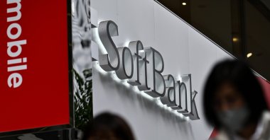 Pedestrians walk past a SoftBank mobile shop in Tokyo, Nov. 9, 2020. (AFP Photo)