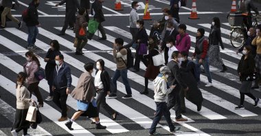 People wearing protective masks to help curb the spread of the coronavirus walk on a pedestrian crossing in Tokyo, Japan, Nov. 9, 2020. (AP Photo)