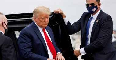 U.S. President Donald Trump holds a "Make America Great Again" cap while arriving to board Air Force One as he departs Florida for campaign travel to North Carolina, Pennsylvania, Michigan and Wisconsin at Miami International Airport in Miami, Florida, U.S., Nov. 2, 2020. (Reuters Photo)