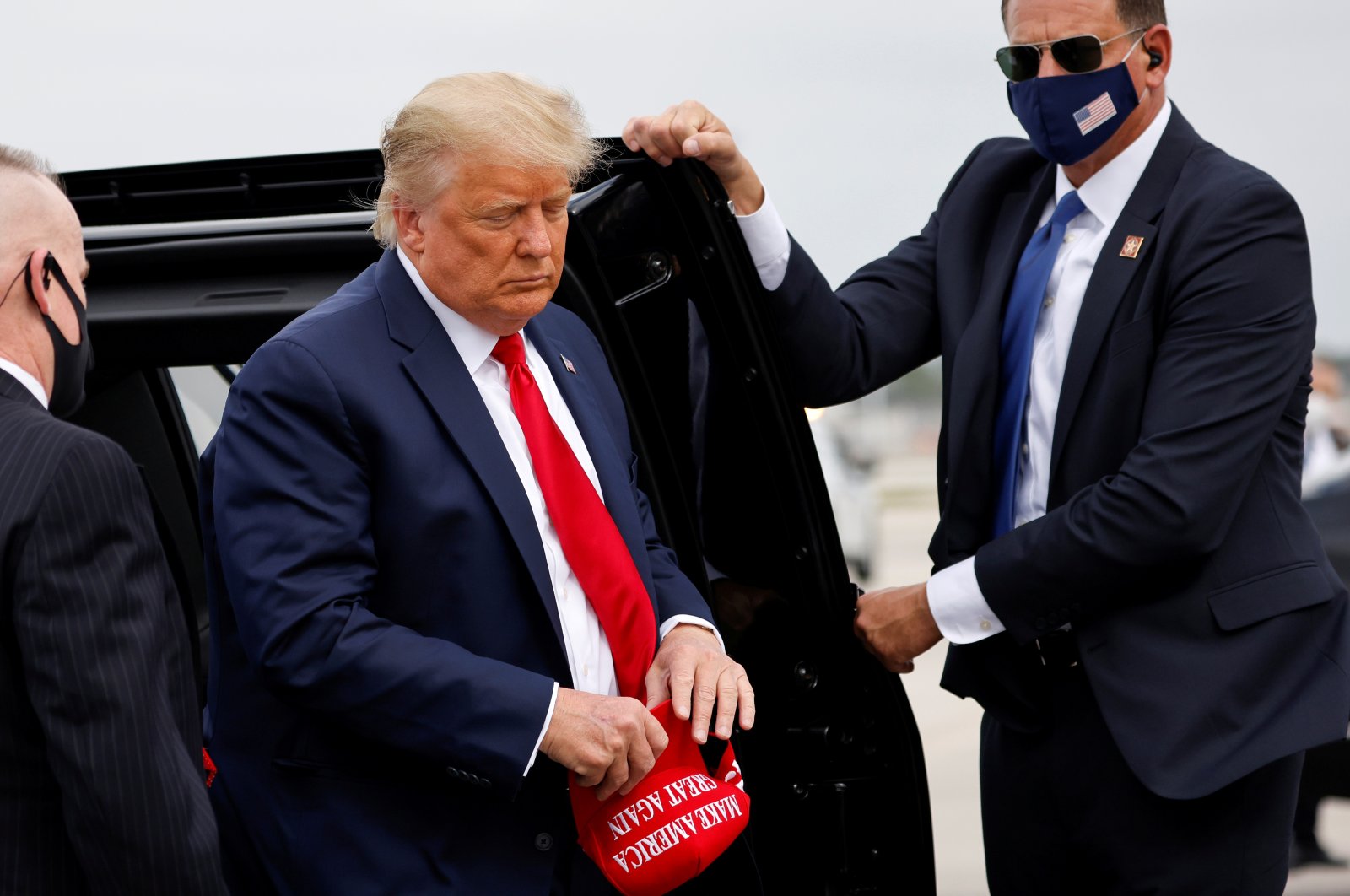 U.S. President Donald Trump holds a "Make America Great Again" cap while arriving to board Air Force One as he departs Florida for campaign travel to North Carolina, Pennsylvania, Michigan and Wisconsin at Miami International Airport in Miami, Florida, U.S., Nov. 2, 2020. (Reuters Photo)
