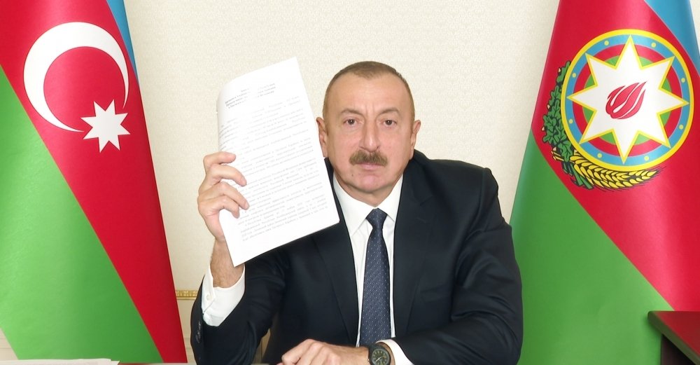 Azerbaijani President Ilham Aliyev holds a copy of the Nagorno-Karabakh peace deal during a televised address, Nov. 10, 2020. (AA Photo)