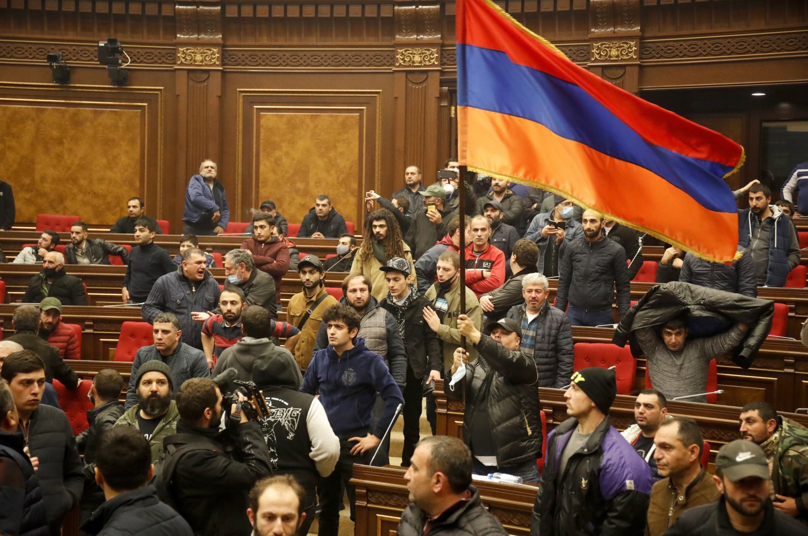 Demonstrators wave an Armenian flag in protest against a peace deal over the Nagorno-Karabakh region, at the national parliament building in Yerevan, Armenia, Tuesday, Nov. 10, 2020. (AP Photo)