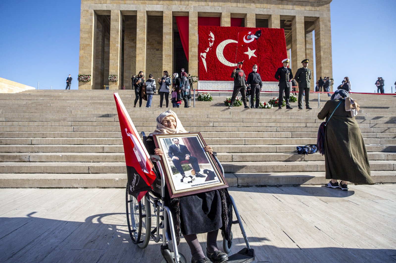 Gülten Gönen, 87, holds a portrait of Mustafa Kemal Atatürk outside his mauseloum Anıtkabir, in the capital Ankara, Turkey, Nov. 10, 2020. (AA Photo)
