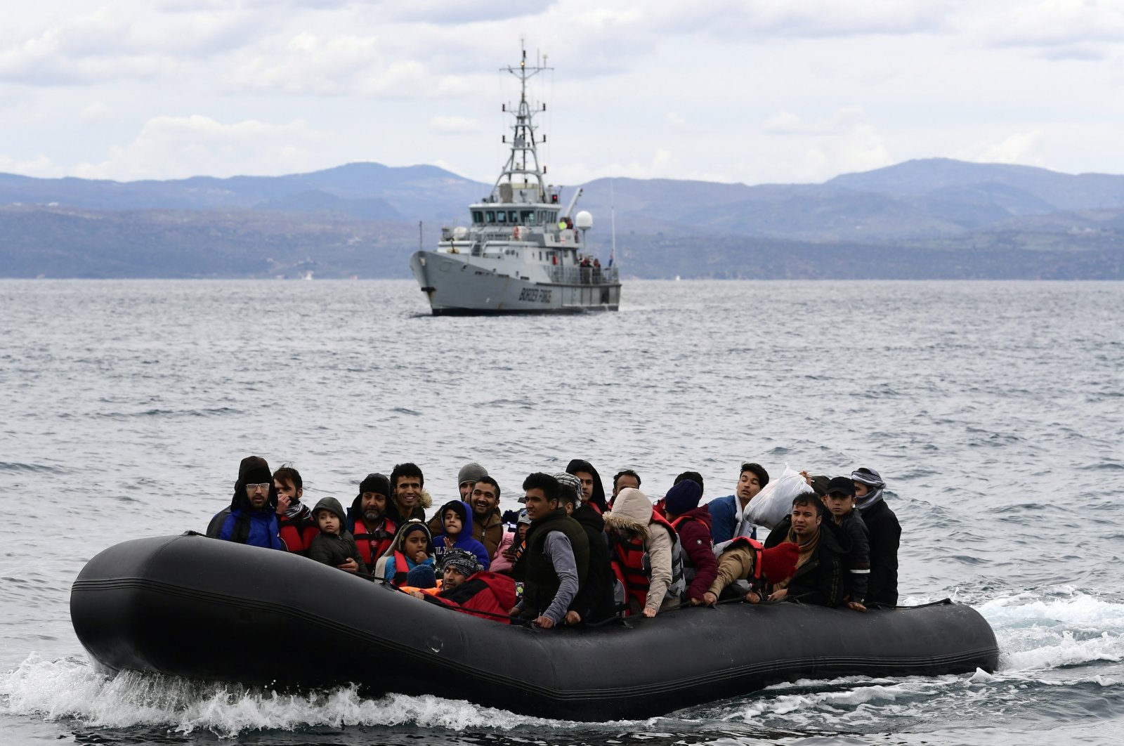 Migrants arrive with a dinghy accompanied by a Frontex vessel at the village of Skala Sikaminias, on the Greek island of Lesbos, after crossing the Aegean Sea from Turkey, Feb. 28, 2020. (AP Photo)