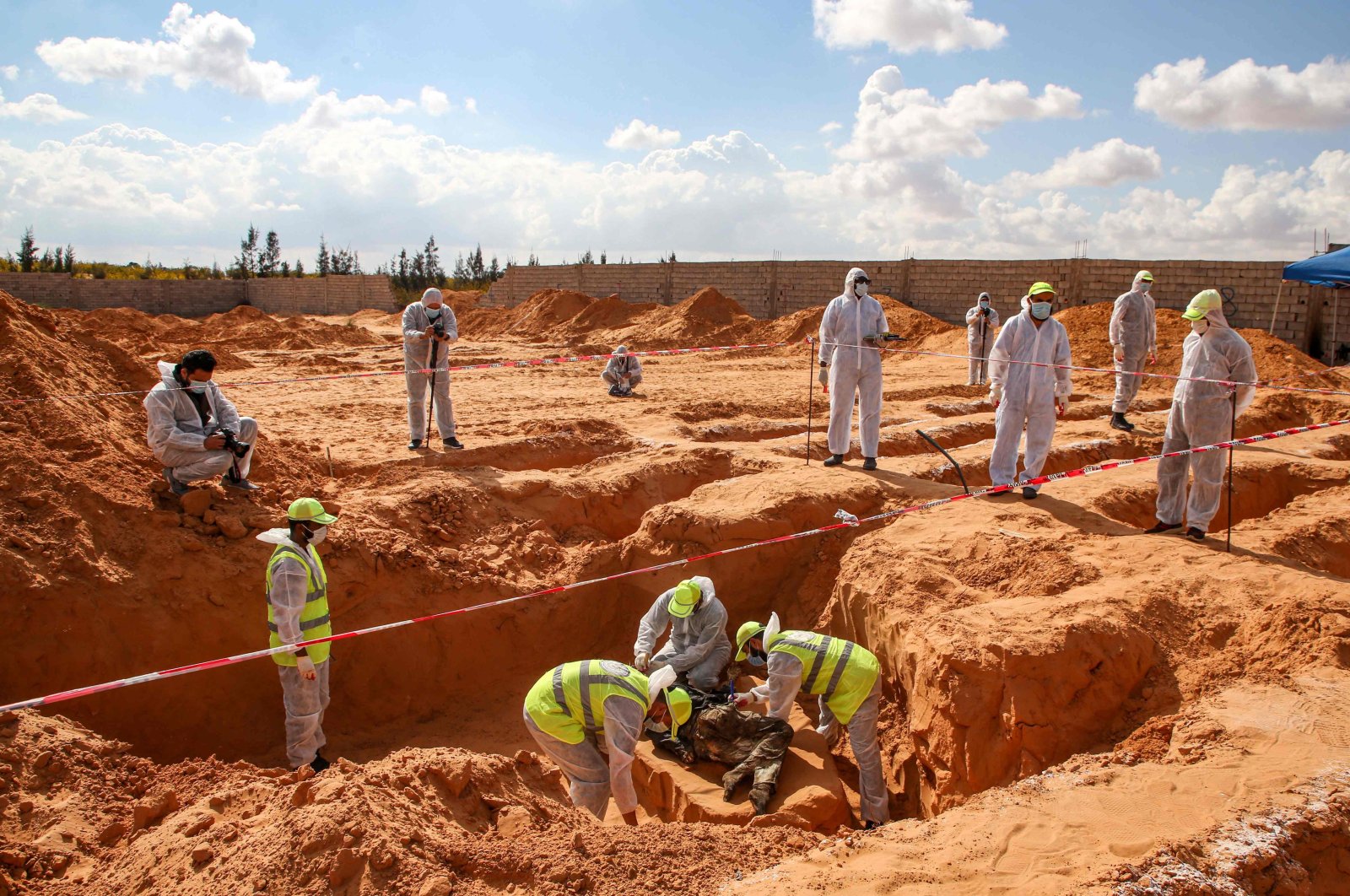 Members of a public body, which is backed by the UN-recognized Government of National Accord (GNA), unearth a body at a mass grave site in western Libya's Tarhuna region on Nov. 7, 2020. (AFP Photo)