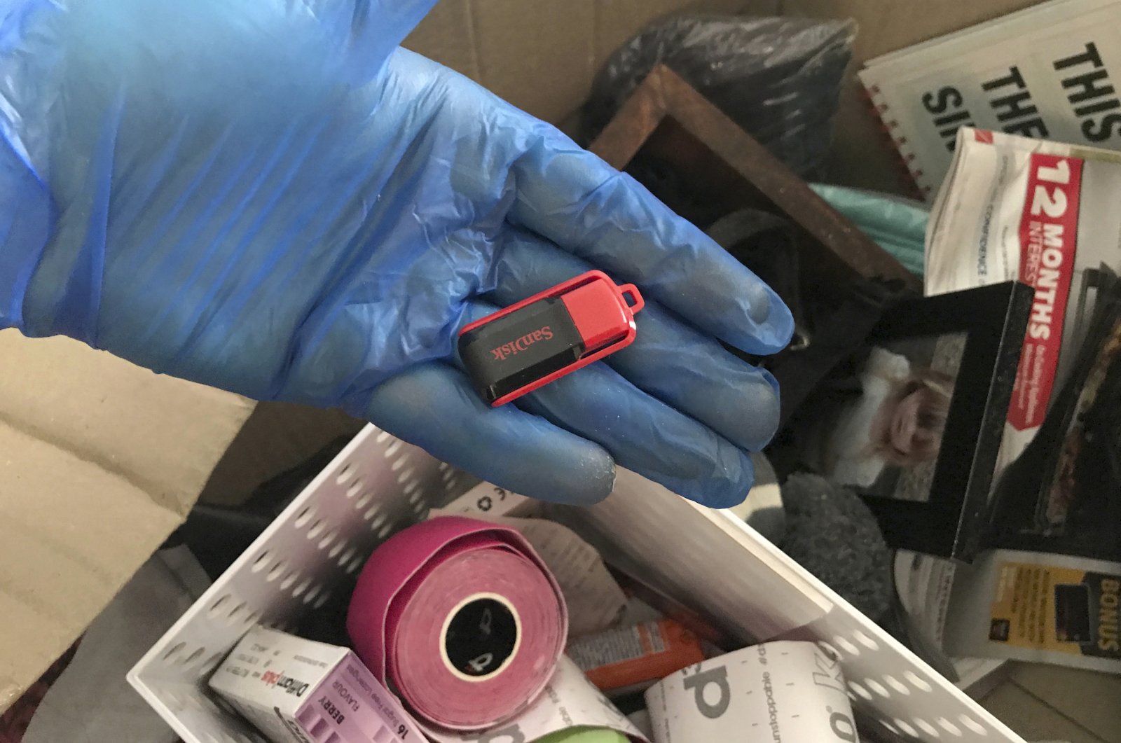 An investigator holds a thumb drive, part of materials that were seized during an investigation into a major child sex abuse ring, New South Wales, Australia, Nov. 11, 2020. (AP Photo)