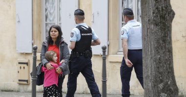 Police Officers patrol as a woman stands with a child in Chantilly, France in this undated picture. (Reuters Photo)
