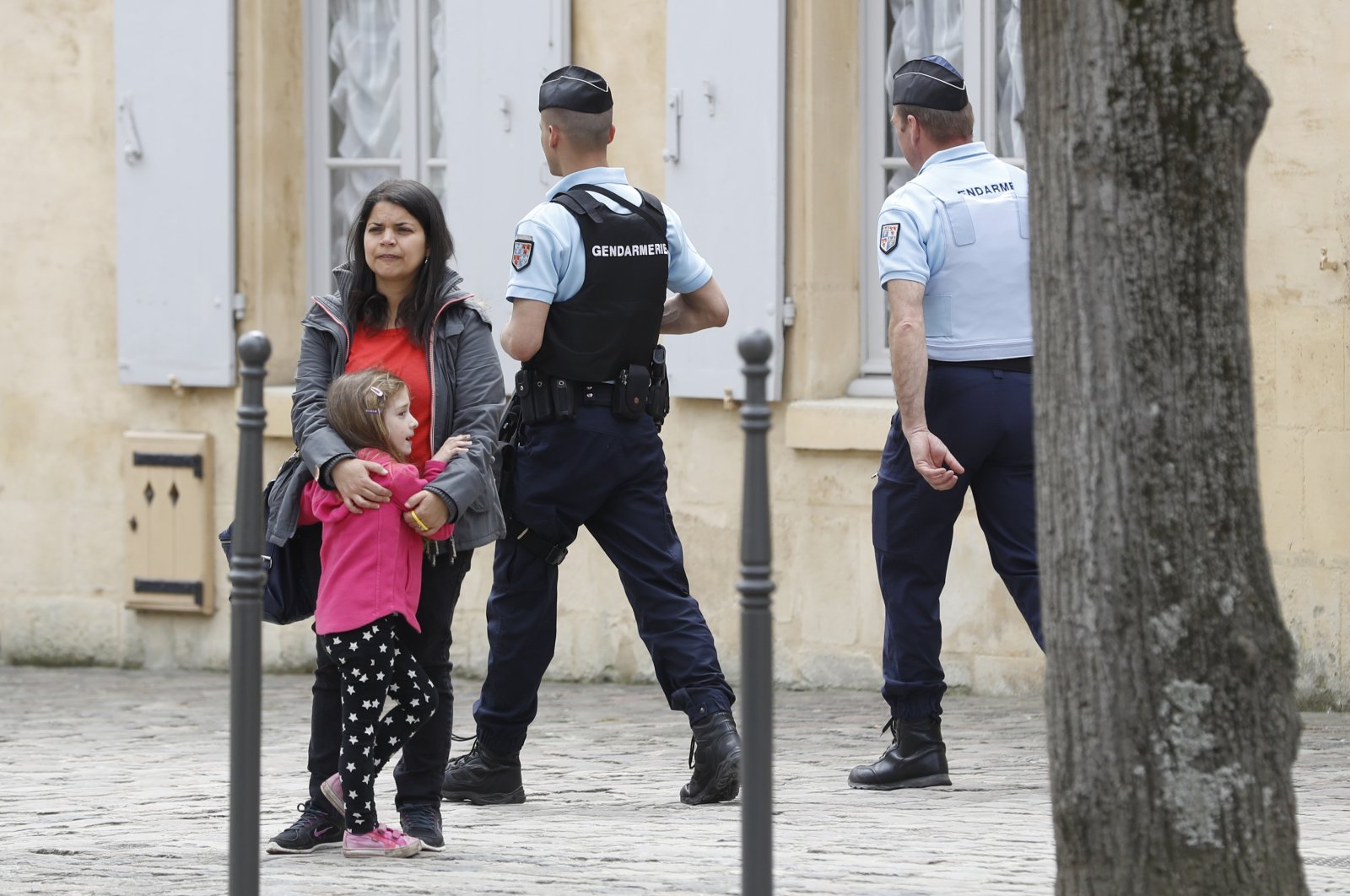 Police Officers patrol as a woman stands with a child in Chantilly, France in this undated picture. (Reuters Photo)
