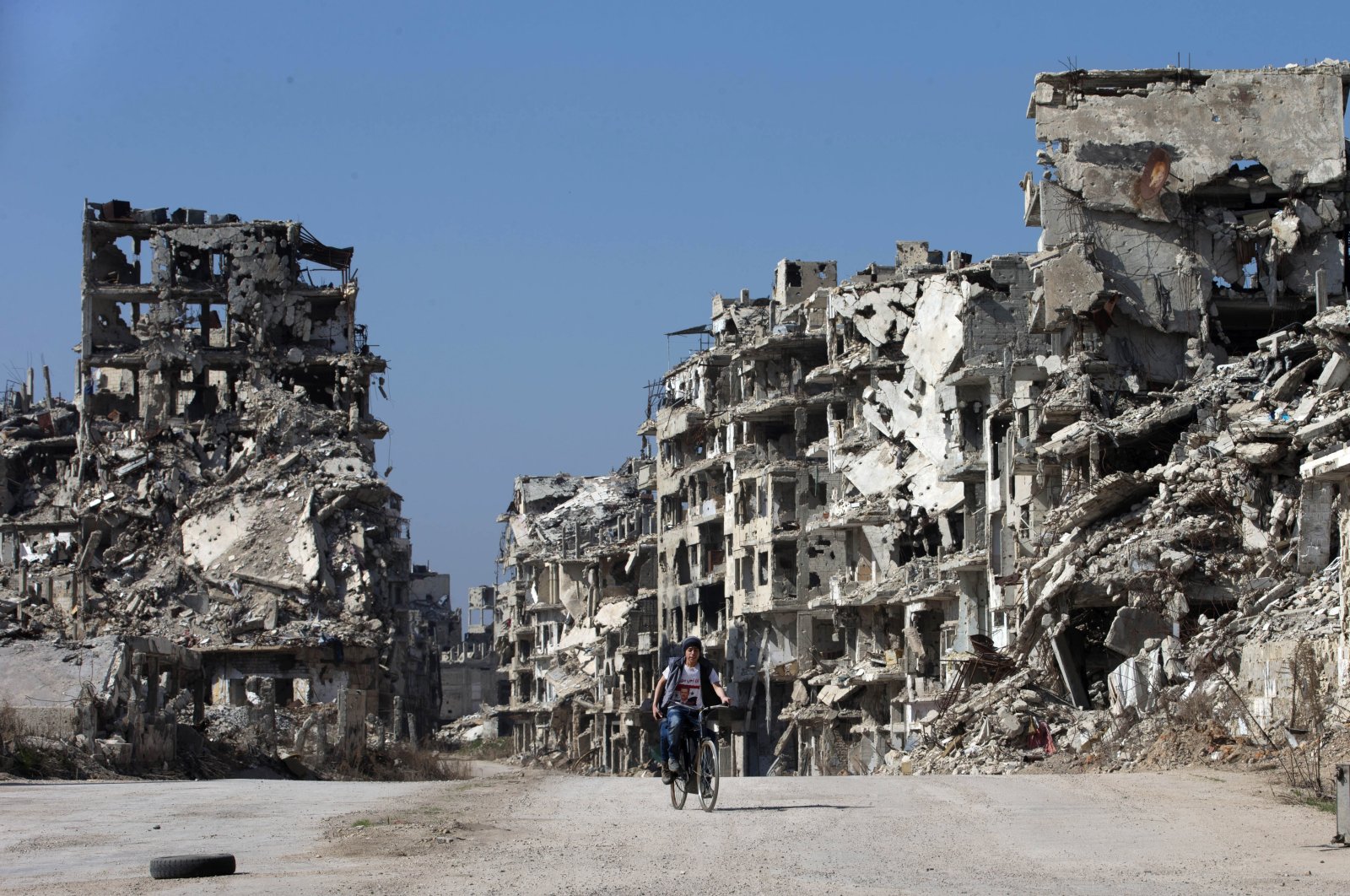 A Syrian boy rides a bicycle through a devastated part of the old city of Homs, Syria, Feb. 26, 2016. (AP Photo)